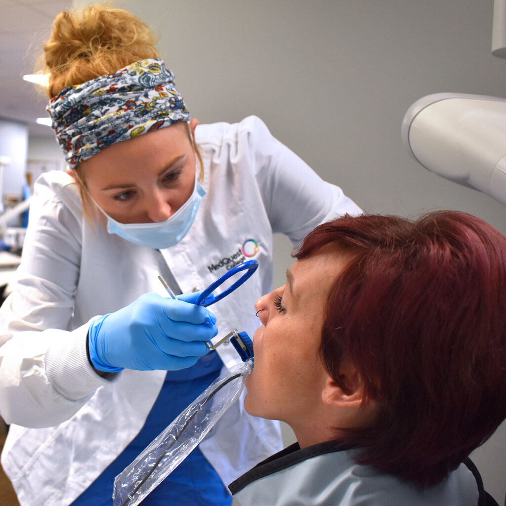 MedQuest College Comprehensive Dental Assisting student putting x-ray bracket in patient's mouth