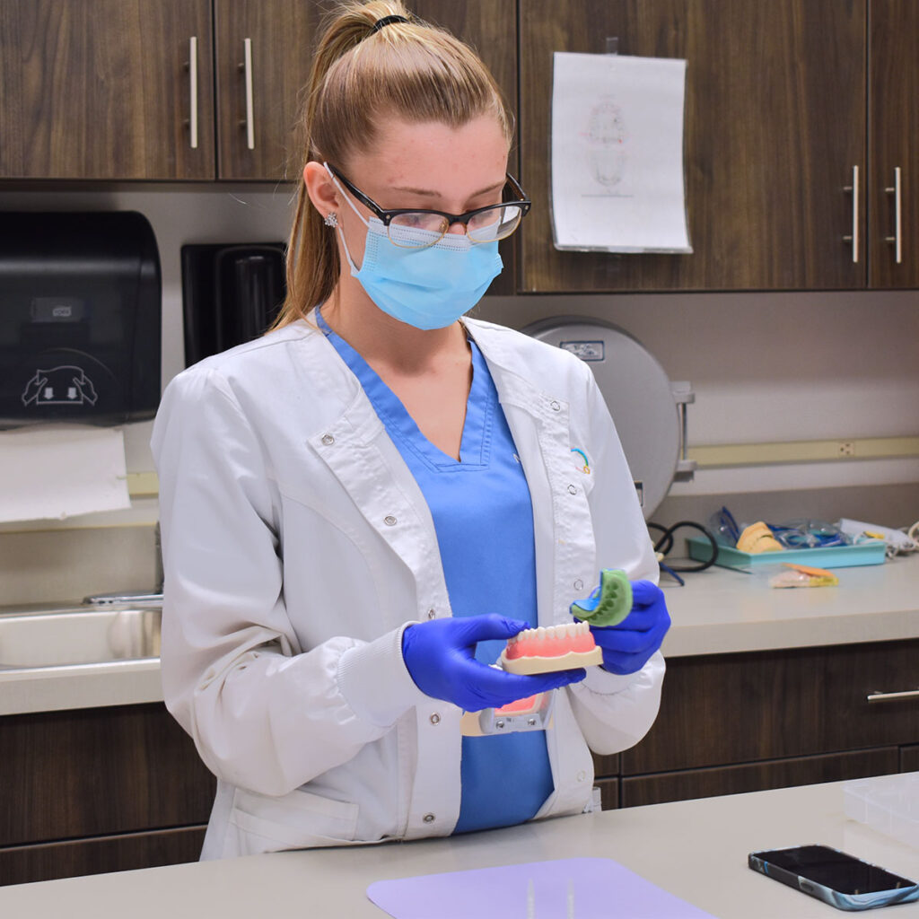 MedQuest College Comprehensive Dental Assisting student working with dental moulds
