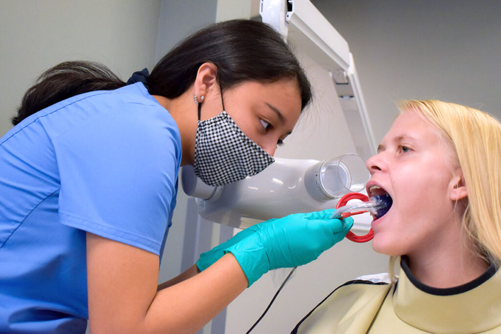 MedQuest College Comprehensive Dental Assisting student with patient at externship
