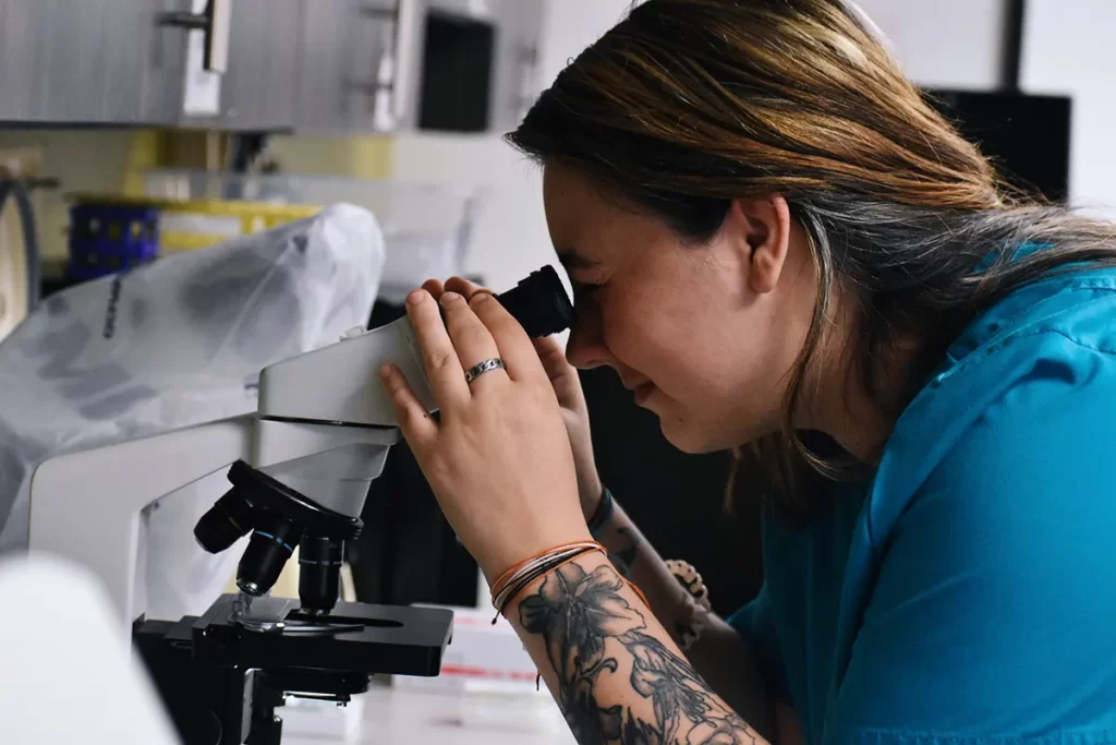 medical assistant student looking through a microscope