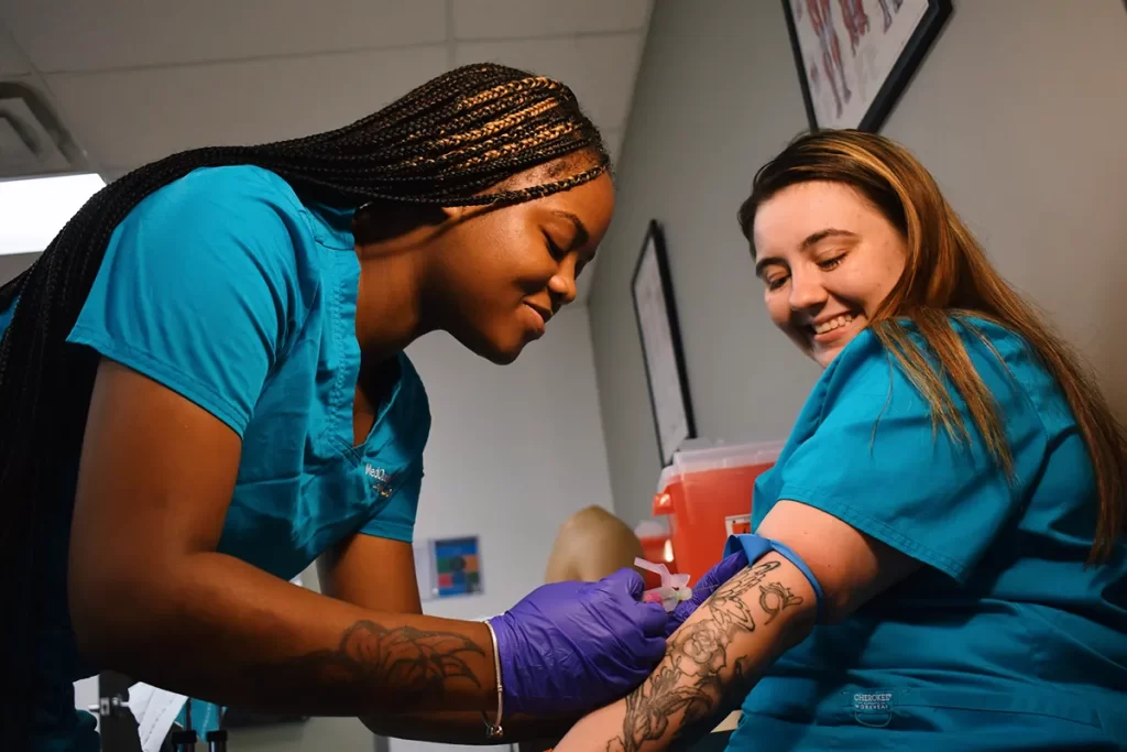 medical assistant student drawing blood from patient