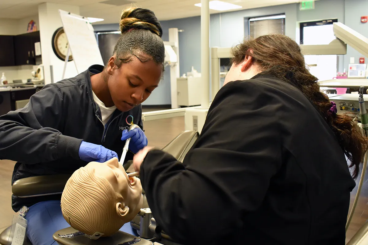 two dental hygienist students working with tools