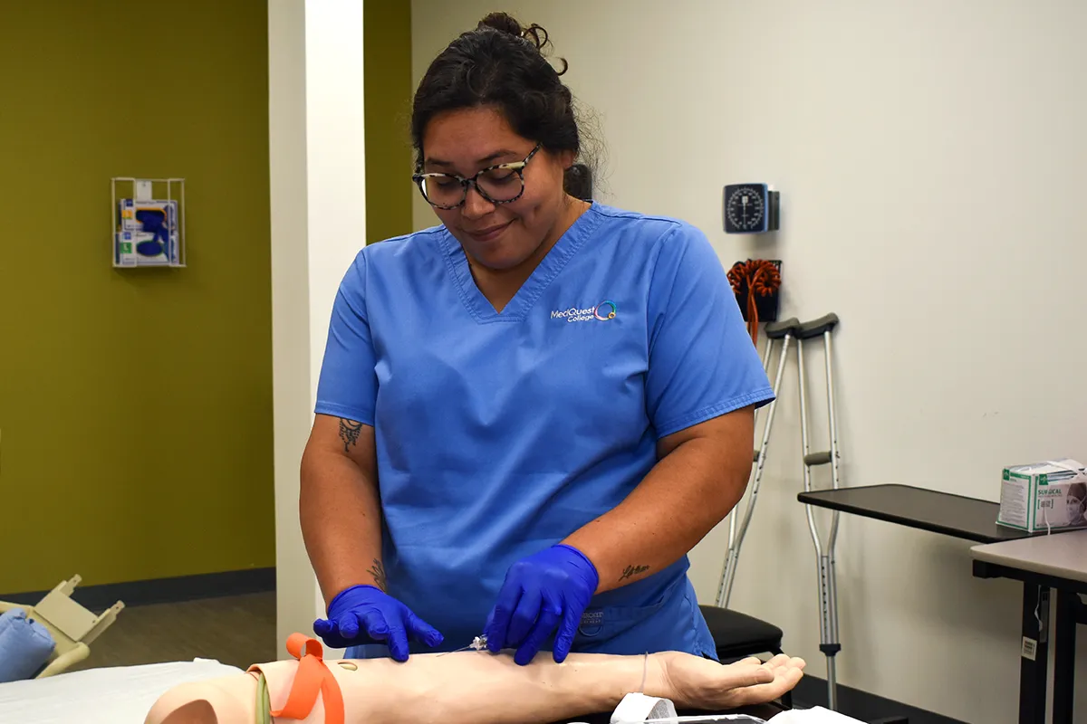 MedQuest Practical Nursing student practicing blood draw on fake arm