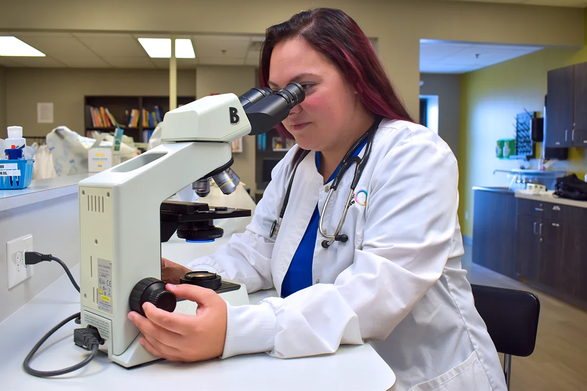 veterinary technician student looking through a microscope